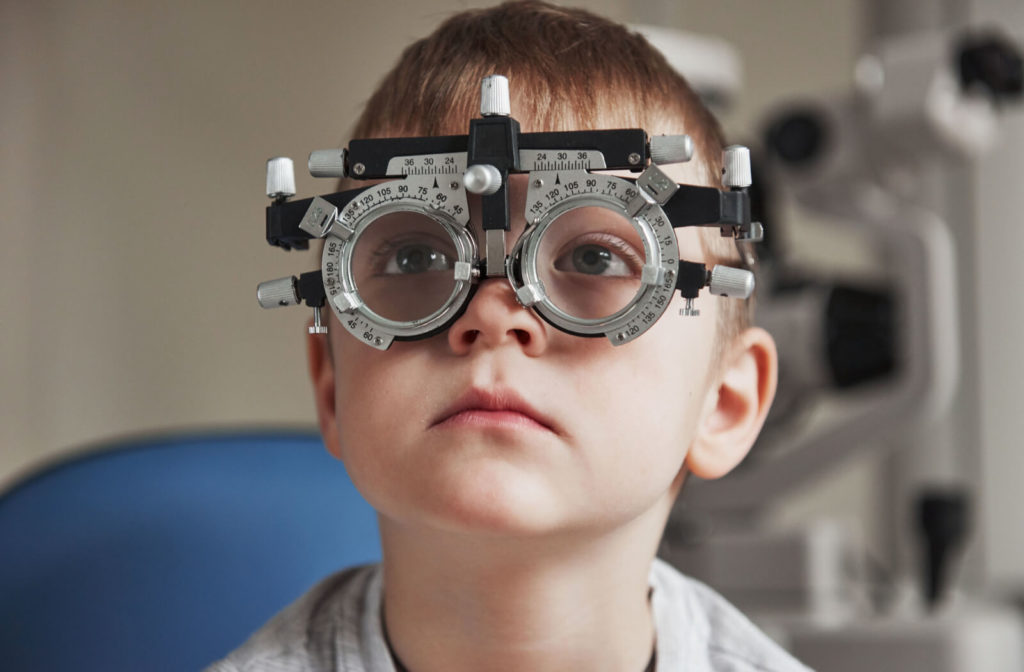 A young boy at the eye doctor having his visual acuity tested to determine if he needs eyeglasses