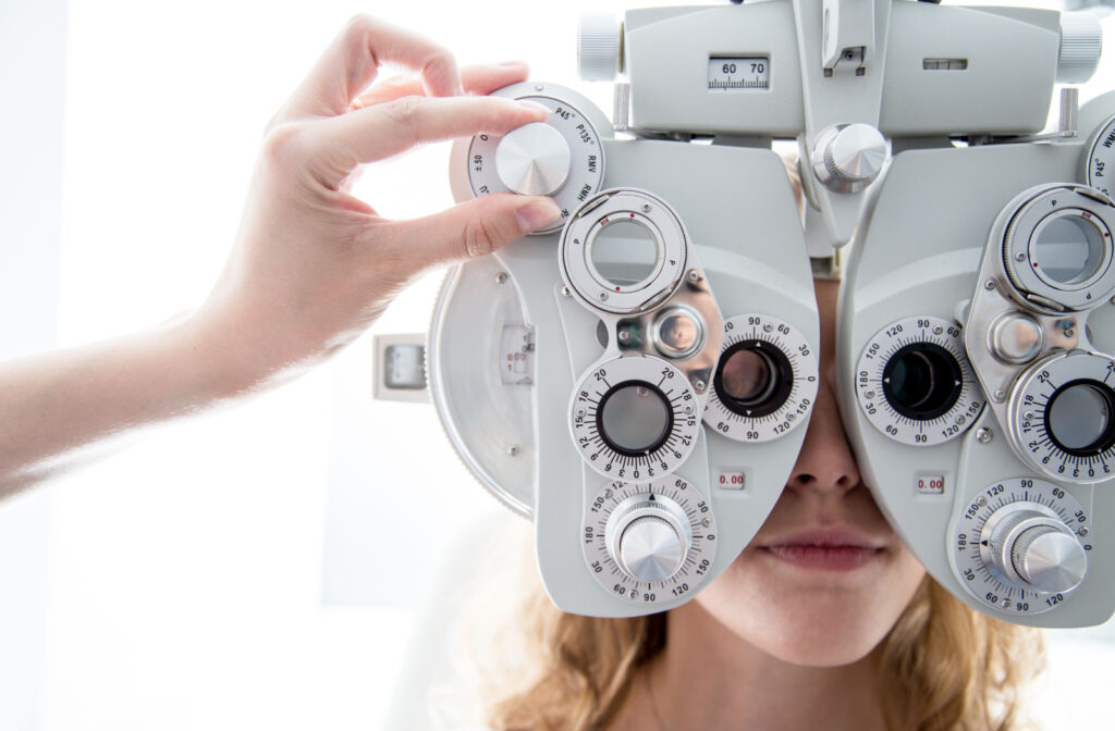 A patient looking through a phoropter while having her eyes examined by an eye doctor to determine is neurolens is right for them.