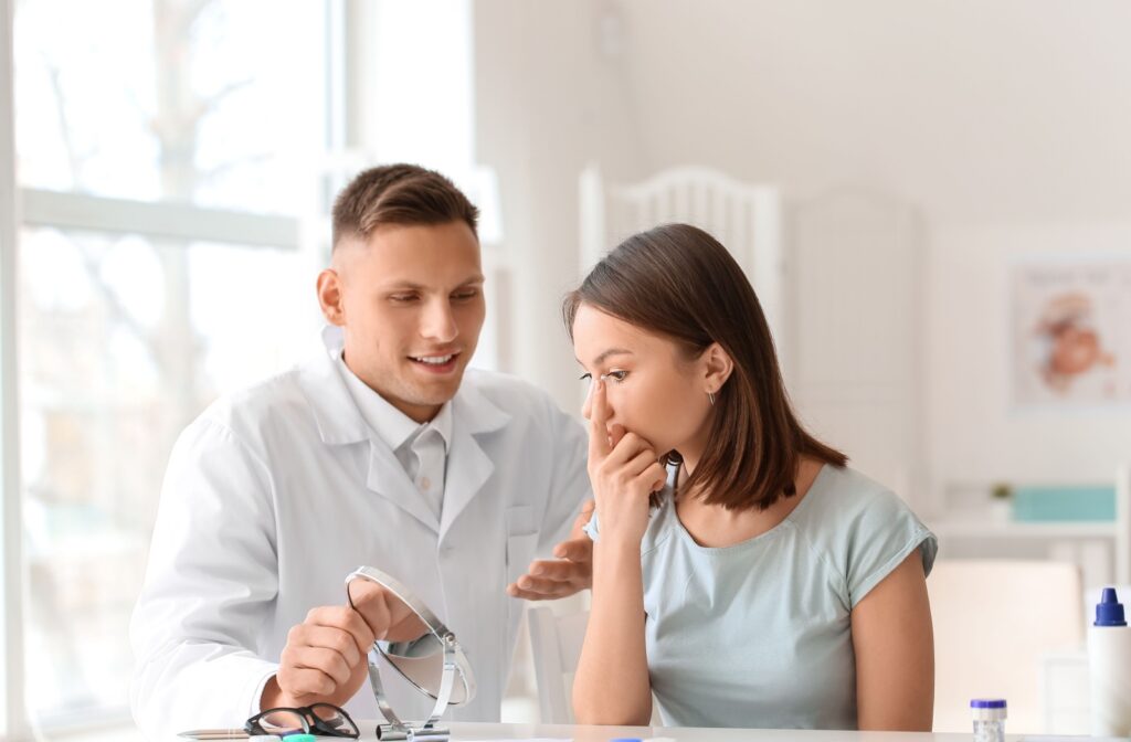 An eye doctor helps a patient insert their contact lenses during a contact lens fitting.