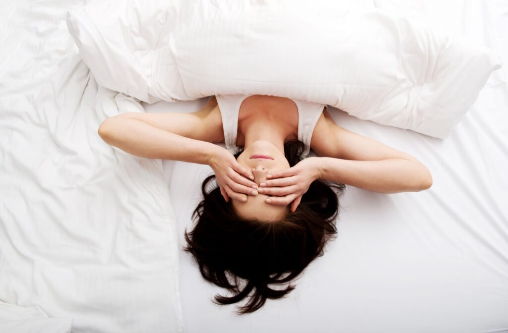 A person rubbing their dry eyes upon waking up in the morning